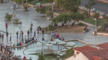 Lizbon, Portekiz 'deki Martim Moniz Meydanı' nın hava görüntüsü. İnsanlar fıskiyenin yanında oturup yürüyorlar. Günbatımında tarihi mimari tarafından çerçevelenen hareketli bir kültür ve çeşitlilik merkezi.