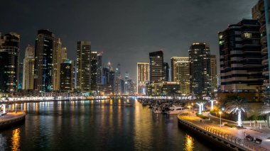 Dubai Marina Kanalı üzerinde trafik olan gezinti ve köprü gece vakti aşırı hızlanma, BAE. Palmiyeler, tekneler ve kuleler ile köprüden görüntü. Yapay kanallı bölge