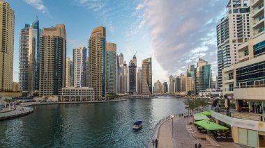 Dubai Marina rıhtımı, Dubai 'deki köprüden gece vardiyasına kadar uzanan kuleleri ve yatları olan Birleşik Arap Emirlikleri. Yapay kanalları ve gökdelenleri olan bir bölge.