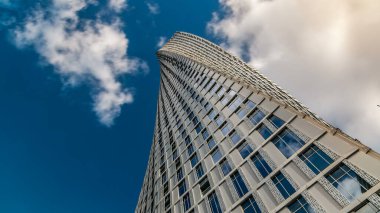 Dubai Marina 'daki Cayan Kulesi (ayrıca Sonsuzluk Kulesi olarak da bilinir). Bakış açısı aşağıdan bulutlu mavi gökyüzüne, kule 90 derecelik bir bükülme ile dünyanın en yüksek binasıdır.