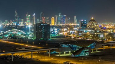 Gece Dubai şehir merkezindeki gökyüzü zaman çizelgesi. Şeyh Zayed 'in çok sayıda aydınlık kulesi, gökdelenleri ve metro istasyonu olan üst manzarası. Yollarda trafik vardı. Ünlü simge.