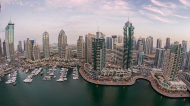 Dubai Marina gezinti güvertesi ve kanalı, gün batımından sonra Dubai, BAE 'de yüzen yat ve tekneler ile gündüz hava manzaralı. Modern kuleler ve yukarıdan gelen trafik. Fisheye merceği