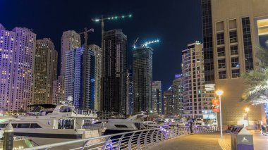 Dubai Limanı 'nda, köprü ve modern kulelerin manzarası Dubai' de gece vakti hiperhıza ulaşan Birleşik Arap Emirlikleri 'nin suya yansıyan yansıması ile hızlı bir gezinti..