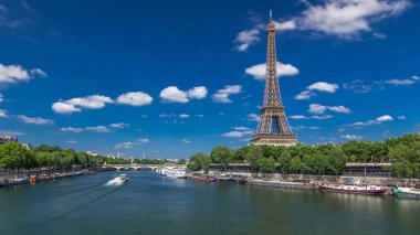 Paris 'teki Seine nehri üzerindeki Bir-Hakeim köprüsünden Eyfel kulesi zaman atlaması. Güneşli bir yaz gününde, mavi gökyüzünde bulutları olan gemi ve tekneler nehirde.