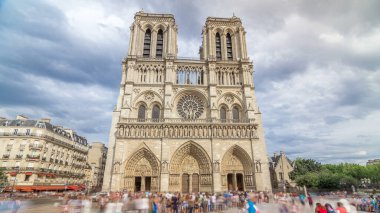 Notre-Dame de Paris 'in ön görüntüsü. Fransa, Paris 'teki Cite Adası' ndaki ortaçağ Katolik katedrali. Girişte uzun bir turist kuyruğu var. Yaz gününde bulutlu bir gökyüzü