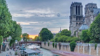 Fransa 'daki Notre Dame de Paris Katedrali üzerinde gün batımı manzarası. Başpiskoposluk Köprüsü 'nden hava görüntüsü. Tekne istasyonu ve rıhtım. Mimari ve çarpıcı gökyüzü simgeleri.