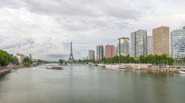 Eyfel Kulesi ve Özgürlük Anıtı modern binalar ve yol trafiği yüksek hızda giderken suya yansıdı. Gün batımından önce Mirabeau Köprüsü 'nden görüntü. Paris, Fransa