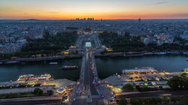 Paris, Fransa 'daki Eyfel Kulesi' nden Palais de Chaillot ile Trocadero 'ya gündüz ve gece geçiş zamanı üzerinde hava manzarası. Seine nehri ve gemisinin geçtiği gözlem güvertesinin üst görüntüsü.