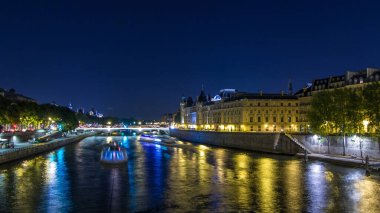 Conciergerie Castle ve Pont au Change ile Seine nehrinin zaman atlaması üzerinde adanın havadan görüntüsü. Gece aydınlatması suya yansıdı. Fransa, Paris