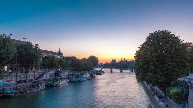 Aerial view to Pont des Arts in Paris after sunset day to night transition timelapse from Pont Neuf, France. Ship on the River Seine near square of the Vert-Galant. Reflection on water clipart