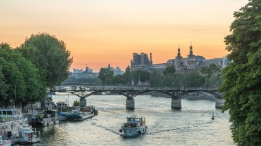 Pont des Arts in Paris after sunset day to night transition timelapse from Pont Neuf, France. Ship on the River Seine near square of the Vert-Galant. View from above with reflection on water clipart