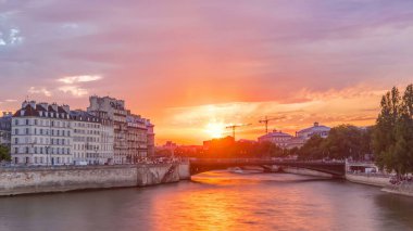 Le Pont D'Arcole bridge at sunset with people and boats timelapse, Paris, France, Europe. Colorful sky at summer day with reflection on river Seine. Construction with cranes on a background clipart