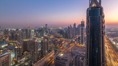 Gün gece geçiş timelapse modern için Dubai Downtown Dubai, Suudi Arabistan, üstten panoramik görünüm kuleleri. Business bay yakınındaki Şeyh Zayed Yolu üzerinde trafik
