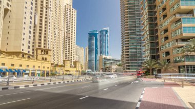 Traffic on the street at Jumeirah Beach Residence and Dubai marina timelapse hyperlapse with skyscrapers, United Arab Emirates. JBR is the largest single phase residential development in the world . clipart