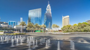 Çeşmeler en yüksek gökdelen timelapse hyperlapse, Dubai ana girişe yakın. Palmiye ve arka plan üzerinde modern kuleli güneşli gün, downtown Dubai yolda trafik
