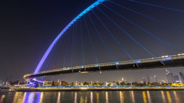 Fütüristik Dubai su kanal ışıklı gece timelapse hyperlapse, Birleşik Arap Emirlikleri, üzerinde yaya köprüsü. Cityscape arka plan üzerinde. Promenade görüntülemek