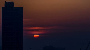 Dubai şehir merkezinde sisli bir sabah gündoğumu. Kızıl gökyüzü sisli, şehrin gelecekteki görüntüsü. Modern kuleleri olan çatıdan havadan yakın görüntü. Dubai, BAE