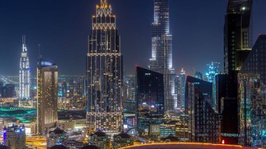 En yüksek bina ve Sheikh Zayed karayolu trafik, Birleşik Arap Emirlikleri Dubai şehir manzarası gece timelapse. Işıklı modern kuleli gökdelenin çatı üzerinden havadan görünümü