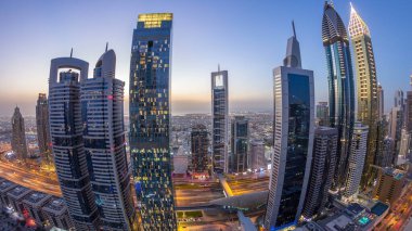 Sheikh Zayed Yolu 'nun gökyüzü manzarası ve Dubai, BAE' deki gece gündüz geçiş zamanı. Finans merkezindeki gökdelenler gün batımından sonra yukarıdan hava manzarası