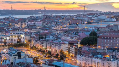 Lizbon 'da gün batımından sonra şehir merkezinin sonbahar gününden geceye geçiş zamanlarında kırmızı çatıları olan panoramik manzarası, Portekiz. Miradouro da Nossa Senhora do Monte bakış açısından üstten görünüm