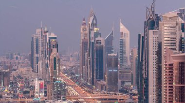 Dubai şehir merkezinde gökdelenler ve Gece geçiş timelapse, Dubai, Birleşik Arap Emirlikleri Şeyh Zayed yol gün havadan görünümü. Modern kuleler ve karayolu üzerinde akşam trafiği