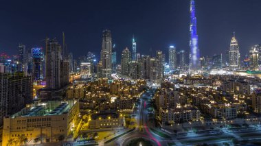 Dubai Şehir Merkezi 'nin ufuk çizgisi Burj Halife ve diğer panoramik manzaralı tüm gece boyunca Dubai, Birleşik Arap Emirlikleri. Gökyüzünde ay var. Geleneksel ve modern binalar.