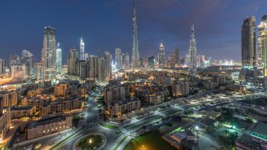 Dubai Şehir Merkezi 'nin ufuk çizgisi gece gündüz Burj Halife ve diğer gökdelenlerle Dubai' deki panoramik manzara, Birleşik Arap Emirlikleri. Daire yolunda trafik var. Modern ve geleneksel binalar.