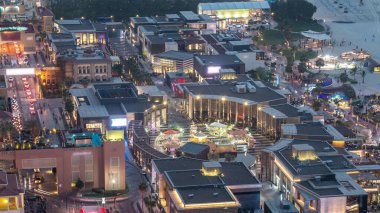 Jumeirah Beach Residence JBR skyline aerial day to night transition timelapse with illuminated buildings. Shops, restaurants and other entertainment from above clipart