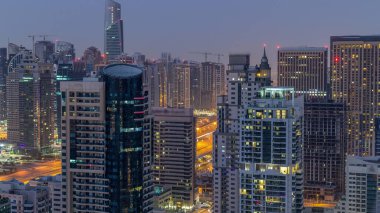 Dubai Marina ve Jlt gece gündüz geçiş timelapse havadan üst görünümü. Dubai, Bae'de gün doğumundan önce gökdelenler. Işıklı modern kuleler ve yolda trafik