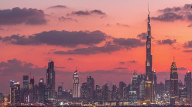 Günbatımından sonra şehrin lüks şehir merkezindeki modern binaların zaman çizelgeleri. Finansal merkez Dubai 'de günden geceye geçiş, Birleşik Arap Emirlikleri