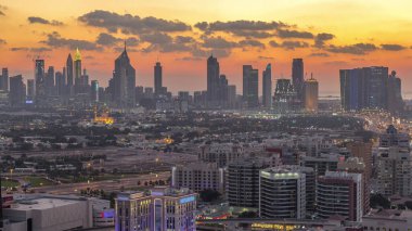 Şehir merkezinde büyük gökdelenler ve onlardan gelen ışıklar ve renkli gökyüzü, Dubai, Birleşik Arap Emirlikleri ile finans bölgesi Timelapse 'nin havadan görünüşü