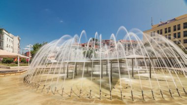 Lisbon şehir merkezinde Martim Moniz Meydanı 'ndaki çeşme. Tepelerde mavi gökyüzü olan tarihi binalar