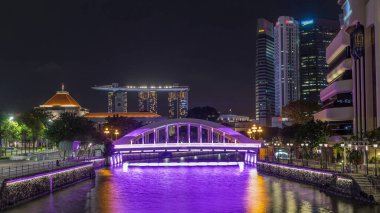 Singapur finans bölgesinin Skyline 'ı ve Elgin Köprüsü' nün arkasındaki Marina körfezi ve Singapur Nehri gece hipervanesi. Parlamento binası sol tarafta.