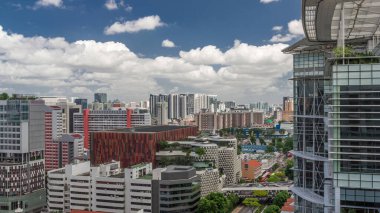 Singapur silueti Victoria caddesi ve Ulusal Kütüphane havadan zaman aralığı hipervanesi. Trafiği olan yeşil ağaçlar. Mavi gökyüzünde bulutlar