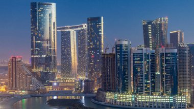 Abu Dabi 'deki Al Reem Adası' ndaki gökdelenler, gün batımından sonra, gece gündüz geçiş zamanları. Aydınlatılmış binaları olan Al Reem Adası 'ndan havadan şehir manzarası