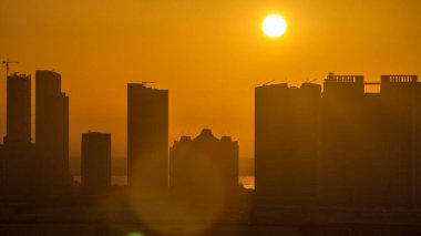 Skyscrapers on Al Reem and Al Maryah Island in Abu Dhabi at sunset timelapse from above. Aerial cityscape from Al Reem Island with modern buildings silhouettes. Orange sky clipart