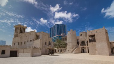 Ajman Müzesi 'ndeki tarihi kalede mavi gökyüzü, Birleşik Arap Emirlikleri ile hızlandırılmış zaman atlaması. Arka planda modern kule