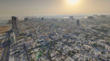 Panorama Ajman 'ın şehir manzarasını sabah güneş doğduktan sonra çatıdan gösteriyor. Ajman, Birleşik Arap Emirlikleri 'nde Ajman Emirliğinin başkentidir..