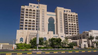 Ajman 'da 5 yıldızlı lüks bir otelin girişinde, UAE' nin Arap Körfezi turkuaz sularının yakınındaki bir yolda trafik vardı..