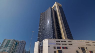 Ajman zaman ayarlı hiperhızlandırılmış modern yeni kuleler. Ajman 'ın yerleşim yeri ve ofis gökdelenleri olan şehir manzarası. Güneş cam yüzeyden yansıyor. Birleşik Arap Emirlikleri.