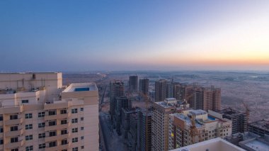 Ajman 'ın çatıdan şehir manzarası. Gün doğumundan gündüze geçiş zamanından önce. Yeni inşaat halindeki bölgeye havadan panoramik görüntü. Birleşik Arap Emirlikleri.