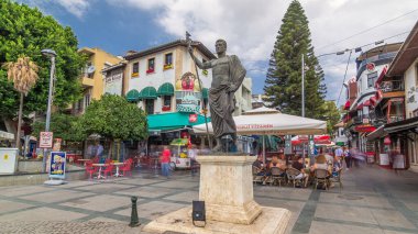 Çok sayıda kafe ve barlar, Attalos II ve Hediyelik eşya heykeli ile Cumhuriyet Meydanı timelapse hyperlapse Antalya'da depolar. Mavi bulutlu gökyüzü yaz gün