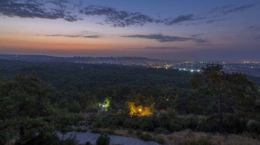 Türkiye 'de gün doğumundan önceki kuşbakışı geçiş zamanı gece gündüz. Hindi. Sabah sisi. Yollarda trafik vardı. Yeşil ağaçlar. Renkli gökyüzü