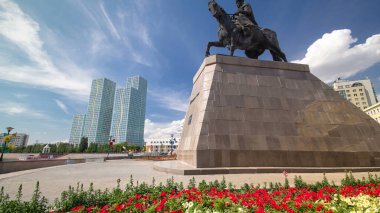 Khan Kenesary Anıtı zaman aşımına uğradı. Mavi gökyüzünün arka planında yeşil kuleleri ve bulutları olan bir liman. Nur-Sultan şehri, Kazakistan. Güneşli bir gün.