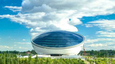 Nazarbayev Merkez ve mavi kule, mavi camda bulutlar ve yansımalar var. Köprüden görüntü. Bulutlu gökyüzü. Nur-Sultan şehri, Kazakistan