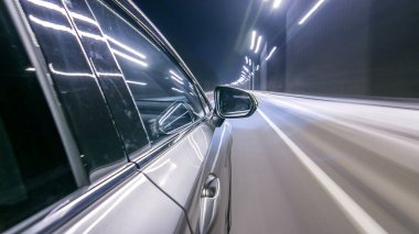 Sokaklarda yüksek hızda araba sürerken zaman ayarlı süratli sürat. Gece şehir yolunda sürgülü hareket ile arabanın yanından görüntüle