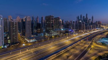 Dubai Yat Limanı gökdelenler hava üstten görünüm güneş doğmadan önce Jlt gelen Dubai gece gün timelapse, Birleşik Arap Emirlikleri için. Işıklı modern kuleleri ve Şeyh zayed yolu üzerinde trafik.