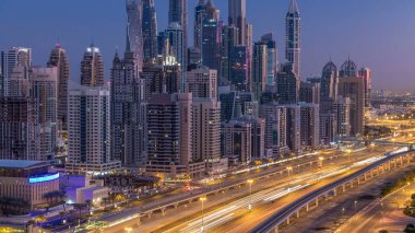 Dubai Yat Limanı gökdelenler hava üstten görünüm güneş doğmadan önce Jlt gelen Dubai gece gün timelapse, Birleşik Arap Emirlikleri için. Işıklı modern kuleleri ve Şeyh zayed yolu üzerinde trafik.