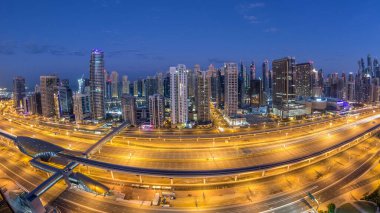 Dubai Yat Limanı gökdelenler hava üstten görünüm güneş doğmadan önce Jlt gelen Dubai gece gün timelapse, Birleşik Arap Emirlikleri için. Işıklı modern kuleleri ve Şeyh zayed yolu üzerinde trafik.