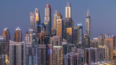 Dubai Yat Limanı kuleleri panorama gün gece geçiş timelapse için dönüş ışıkları. Gökdelenler, BAE gece aydınlatma. Hava Jlt görünümünden